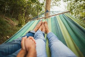 man and woman in love lying in hammock embracing photo