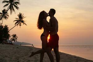 young sexy romantic couple in love happy on summer beach together having fun wearing swim suits photo