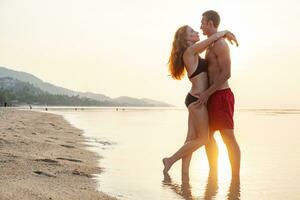 joven sexy romántico Pareja en amor contento en verano playa juntos teniendo divertido vistiendo nadar trajes foto