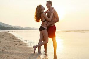 joven sexy romántico Pareja en amor contento en verano playa juntos teniendo divertido vistiendo nadar trajes foto