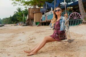 elegante mujer en verano vestir vacaciones caminando en playa con Gafas de sol foto