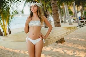 joven sexy mujer en blanco bikini traje de baño en tropical playa foto