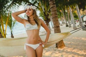 joven sexy mujer en blanco bikini traje de baño en tropical playa foto