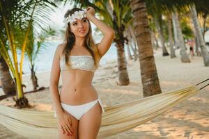 young sexy woman in white bikini swimsuit on tropical beach photo