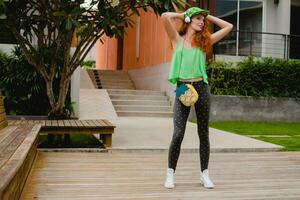 young stylish hipster ginger woman, dancing listening music photo