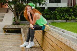 young stylish hipster happy ginger woman, listening music, photo