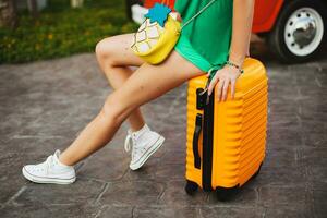 woman traveler with orange suitcase, traveling around world photo