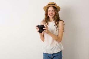 young pretty woman in summer vacation style outfit holding vintage photo camera