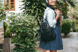 young stylish woman walking, listening to music on headphones photo