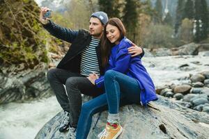 young hipster couple in love on winter vacation in mountains photo