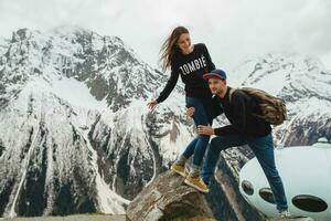 young hipster couple in love on winter vacation in mountains photo