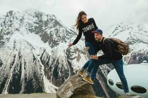 young hipster couple in love on winter vacation in mountains photo