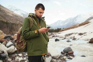 young hipster man hiking in mountains photo