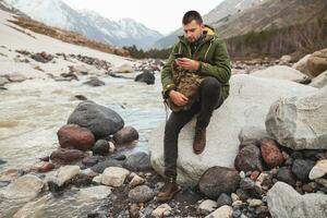 joven hipster hombre excursionismo en montañas foto