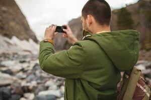 young hipster man hiking in mountains photo