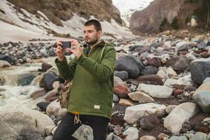 young hipster man hiking in mountains photo