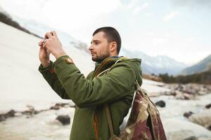 young hipster man hiking in mountains, winter vacation photo