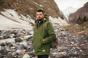 joven hipster hombre excursionismo en montañas, invierno vacaciones foto