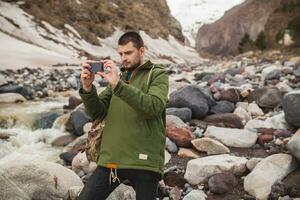 joven hipster hombre excursionismo en montañas, invierno vacaciones foto