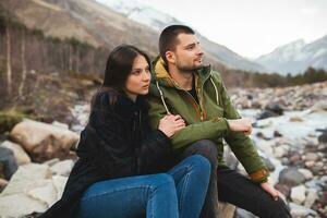 young beautiful hipster couple hiking in mountains photo