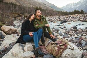 young beautiful hipster couple hiking in mountains photo