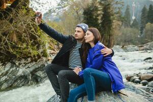 young hipster couple in love on winter vacation in mountains photo