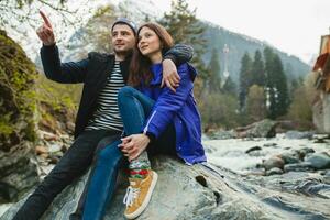 young hipster couple in love on winter vacation in mountains photo