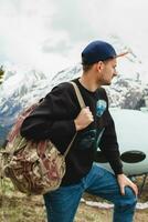 young hipster man sitting in mountains photo