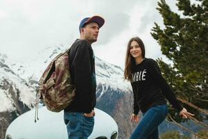 young hipster couple in love on winter vacation in mountains photo