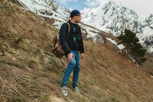 young hipster man sitting in mountains photo