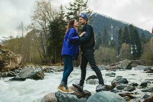 young hipster couple in love walking in mountains photo