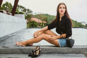 joven elegante hipster mujer, sentado a piscina foto