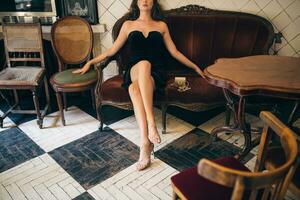 elegant beautiful woman sitting in vintage cafe in black velvet dress photo