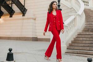 beautiful sexy rich business woman in red suit walking in city street, spring summer fashion trend photo