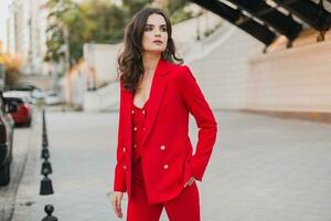 beautiful sexy rich business woman in red suit walking in city street, spring summer fashion trend photo