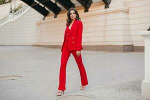 beautiful sexy rich business woman in red suit walking in city street, spring summer fashion trend photo