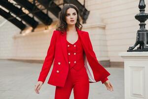 beautiful sexy rich business woman in red suit walking in city street, spring summer fashion trend photo