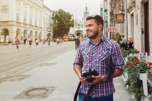 joven hermoso hipster hombre caminando con foto cámara