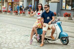 young beautiful hipster couple riding on motorbike city street photo