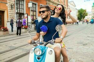 young beautiful hipster couple riding on motorbike city street photo