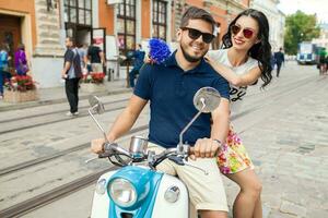 young beautiful hipster couple riding on motorbike city street photo