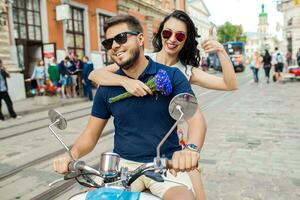 young beautiful hipster couple riding on motorbike city street photo