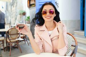 atractivo joven mujer Bebiendo vino foto