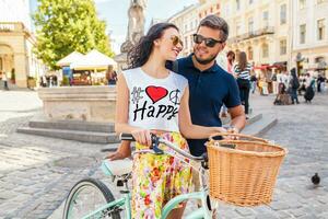 young beautiful hipster couple in love walking with bicycle photo