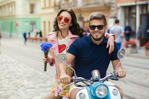 young beautiful hipster couple riding on motorbike city street photo