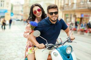 young beautiful hipster couple riding on motorbike city street photo