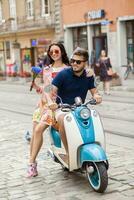 young beautiful hipster couple riding on motorbike city street photo