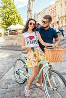 young beautiful hipster couple in love walking with bicycle photo