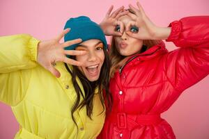 bonito mujer amigos en vistoso abajo chaqueta foto