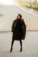 stylish woman in winter autumn fashion trend black puffer coat photo